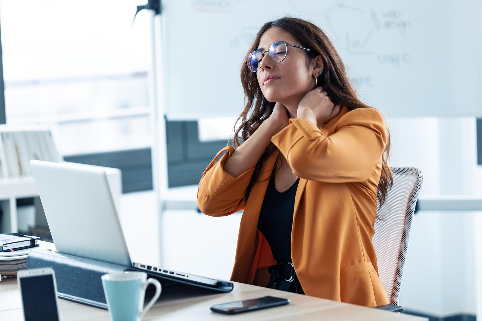 Business young woman with neck pain working with laptop in the office.